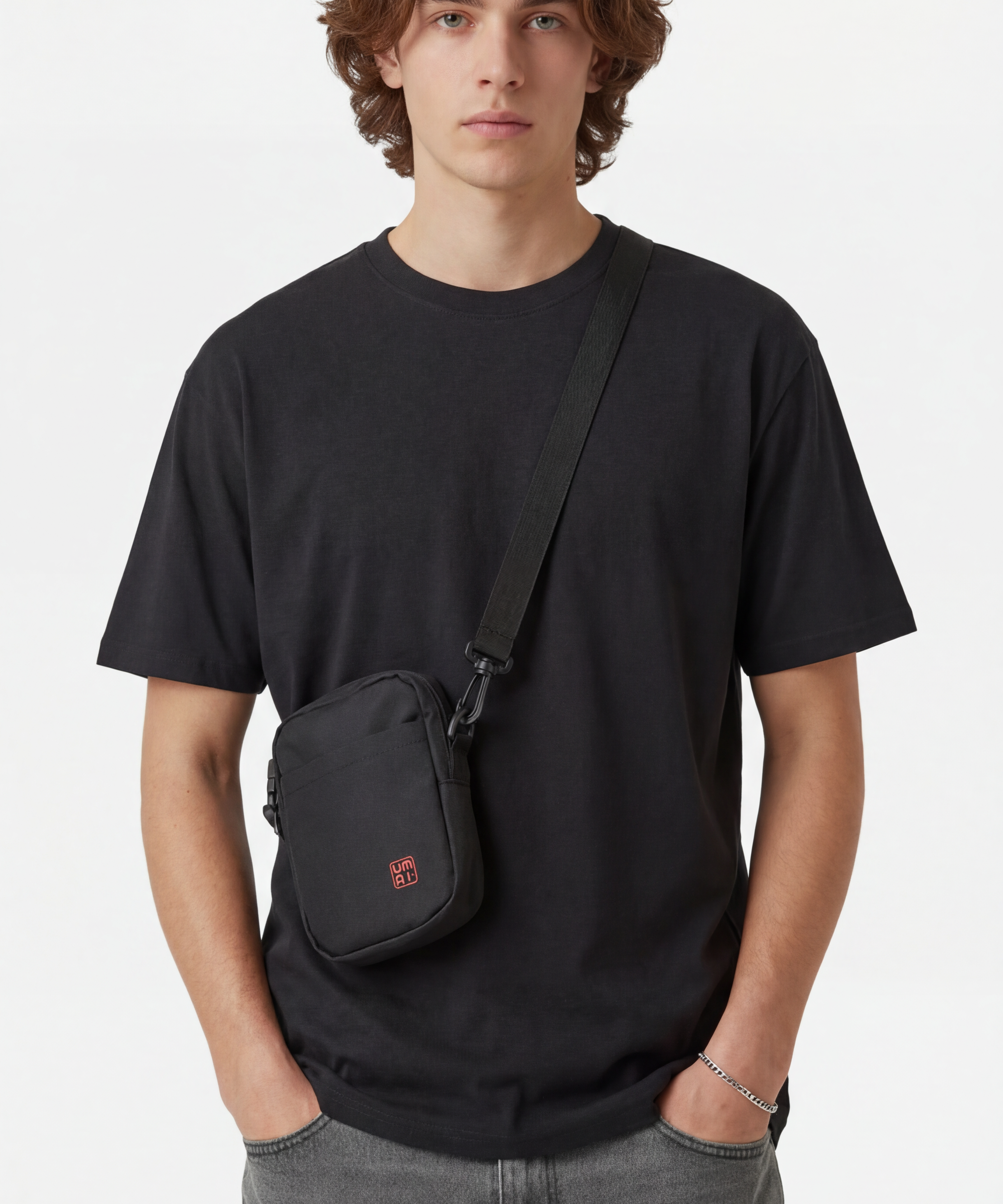 wearing_the_cross_body_bag_he_is_also_wearing_just_a_plain_black_t-shirt_and_a_silver_bracelet.png